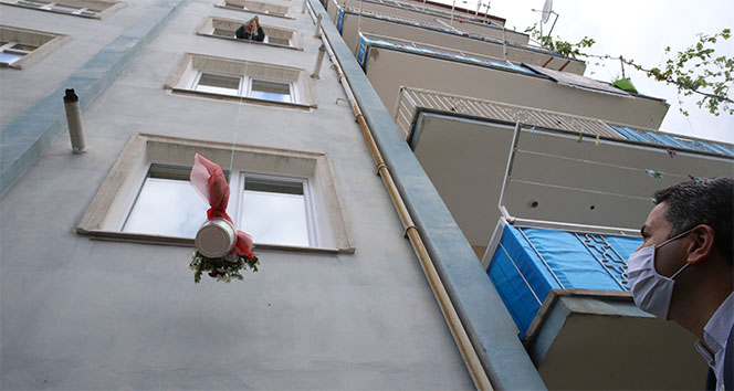 Anneler günü çiçeğini balkondan uzattığı sepetle aldı